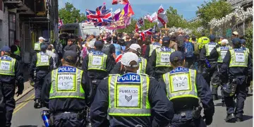 Police from Sussex follow behind protestors raising flags at a protest in Brighton which led to Ryan Bridge being arrested for common assault