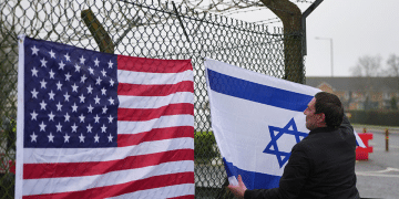 People who describe themselves as patriots display US and Israel flags as they set up their counter protest ahead of the protest by CND at RAF Fairford on March 7, 2026 in Fairford, England.