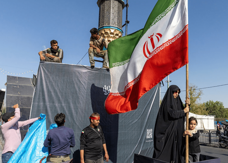 A woman is seen holding the Iranian Flag on June 15, 2026 in Tehran, Iran. According to reports, the U.S. and Iran have signed a preliminary agreement to end the war and open the Strait of Hormuz. The UAE is alleged to have agreed to unlock funds frozen in foreign banks under US sanctions for Iran.