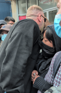 A heavy set man leans over a small woman who looks concerned Tommy Robinson