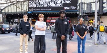 Bite Back campaigners in front of anti junk food ad on billboard