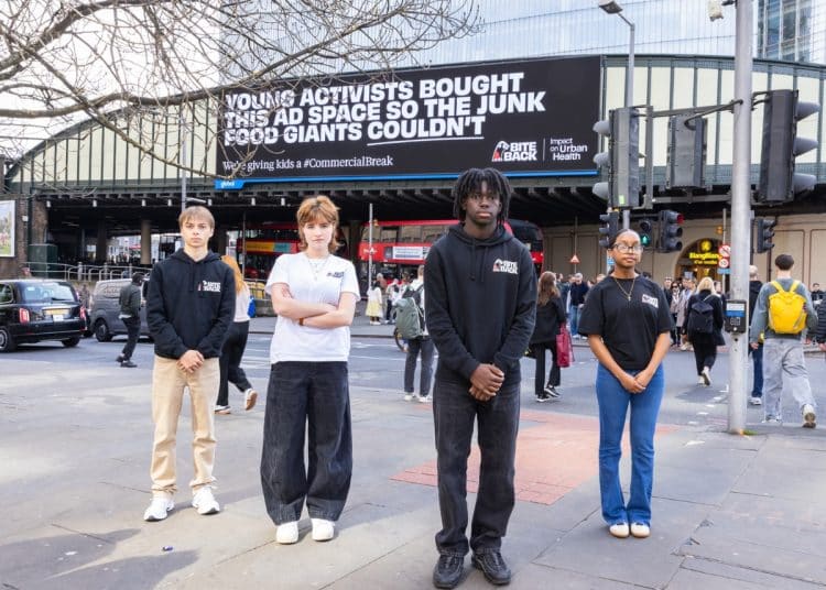 Bite Back campaigners in front of anti junk food ad on billboard