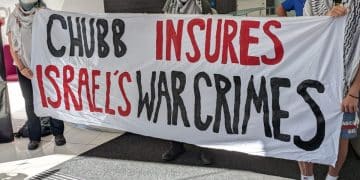Chubb lobby protesters lod a banner saying Chubb Insures Israel's War Crimes