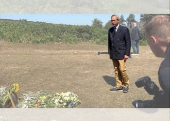 Nigel Farage laying a wreath in a field