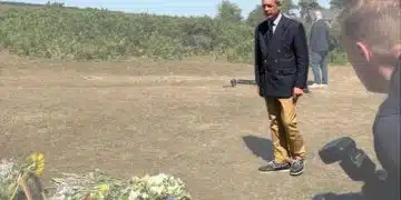 Nigel Farage laying a wreath in a field