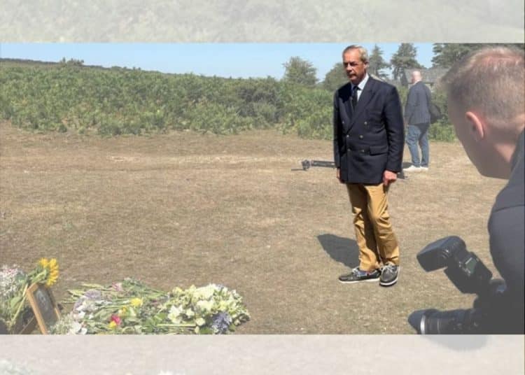 Nigel Farage laying a wreath in a field
