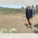 Nigel Farage laying a wreath in a field