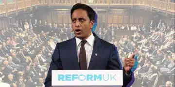 Zia Yusuf at a Reform-branded podium speaking with an image of a packed House of Commons behind him