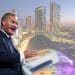 Rupert Lowe of Restore Britain and a scene of Manchester city centrescape with vibrant infrastructure in the background