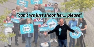 Reform UK politician Adrian White with others holding Reform logo posters behind him