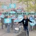 Reform UK politician Adrian White with others holding Reform logo posters behind him