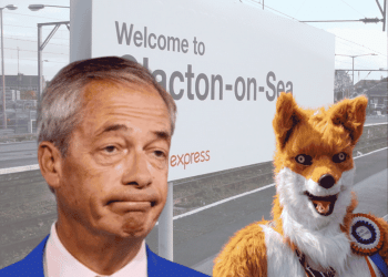 An image of Clacton-On-Sea's railway track with the sign in show. In front of them on the right is Rob Pownall dressed in his red fox outfit. On the left is an image of Nigel Farage's bust, and he is looking perplexed