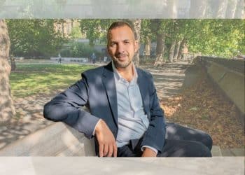 Zack Polanski of the Green Party sat on a bench outside in a relaxed manner posing for camera