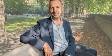 Zack Polanski of the Green Party sat on a bench outside in a relaxed manner posing for camera