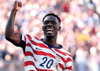 Folarin Balogun #20 of the United States celebrates scoring his team's first goal during the FIFA World Cup 2026 Round of 32 match between USA and Bosnia-Herzegovina on July 1, 2026 in Santa Clara, California, with a bicep flex