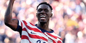 Folarin Balogun #20 of the United States celebrates scoring his team's first goal during the FIFA World Cup 2026 Round of 32 match between USA and Bosnia-Herzegovina on July 1, 2026 in Santa Clara, California, with a bicep flex