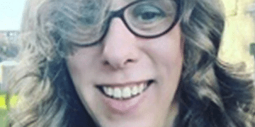 Close up selfie of Heather Herbert, who wears cat eye shaped glasses and has bouncy curls in her hair, and made mean comments online about Ann Widdecombe dying