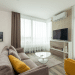 A modern living room, immaculately furnished, with an air conditioning unit on the wall above the TV. Hot weather will make more residents consider installing these.