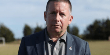 Howard Beckett looking a bit glum posing for a photo outdoors on a field in 2021