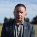 Howard Beckett looking a bit glum posing for a photo outdoors on a field in 2021
