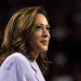 Kamala Harris smiling with a closed mouth in a smart suit looking into the distance, looking relaxed and assured