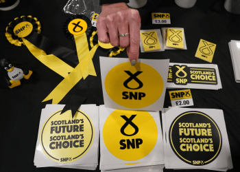 A table with SNP promotional items like stickers that say 'Scotland's Future, Scotland's Choice', and ribbons, in October 2022