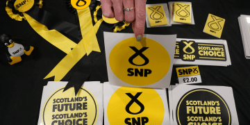 A table with SNP promotional items like stickers that say 'Scotland's Future, Scotland's Choice', and ribbons, in October 2022