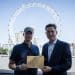 MPs Clive Lewis and Charlie Maynard in front of the Thames and London Eye, holding an open letter concerning Thames Water