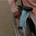 Close-up of the hand of a black woman pushing her wheelchair, she put her surgical face mask on the armrest. Police have warned unwell campaigners their health is not an automatic pass for wearing a face mask.